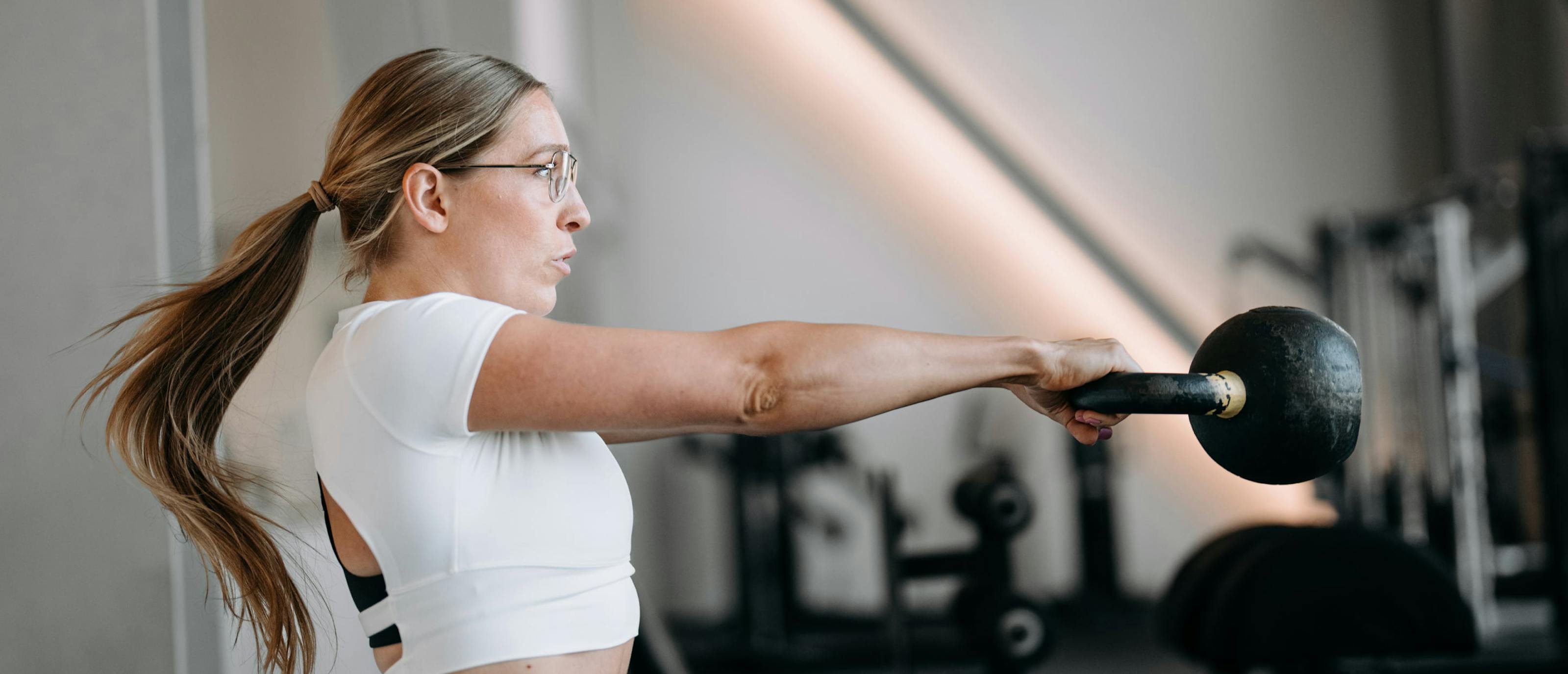 Woman swinging kettlebell in Rio eyeglasses