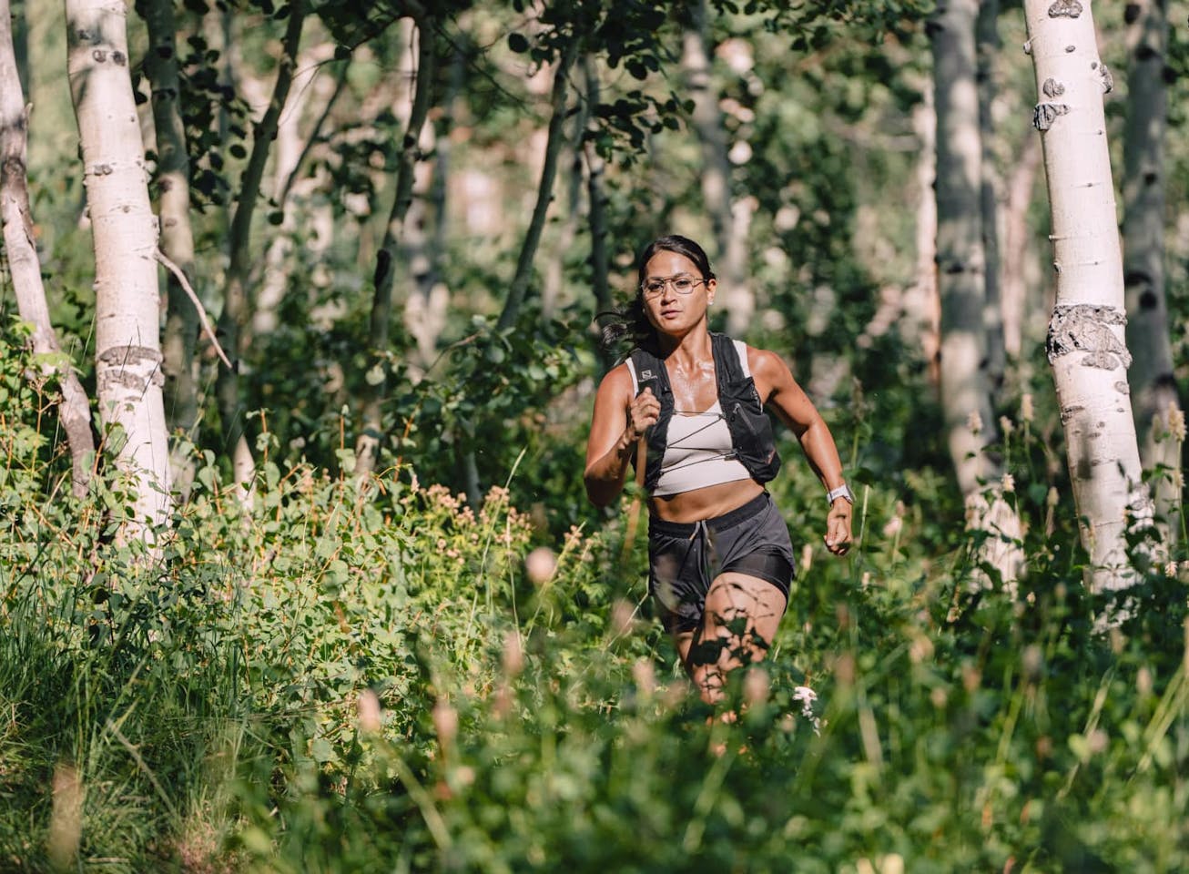 Woman trail running outside wearing Rio Titanium eyeglasses
