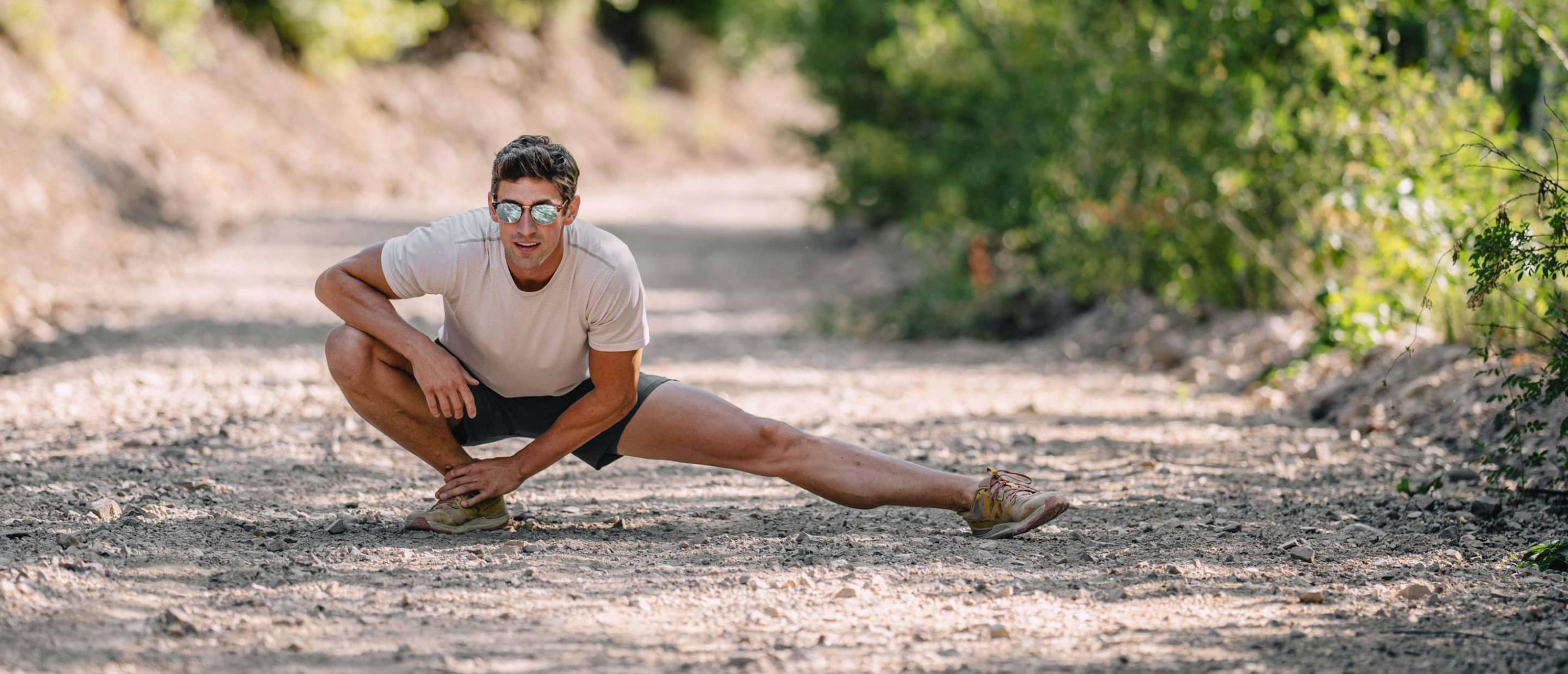 Man stretching outside wearing Cambridge sunglasses