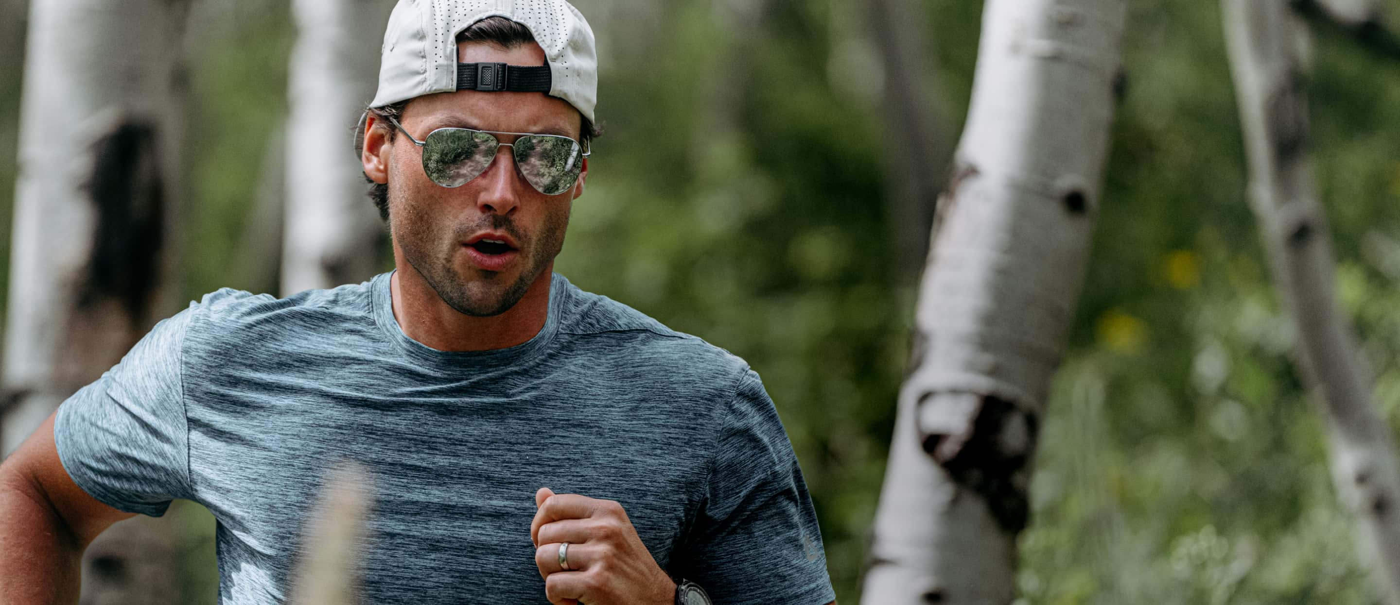 Man running in woods wearing Phantom sunglasses