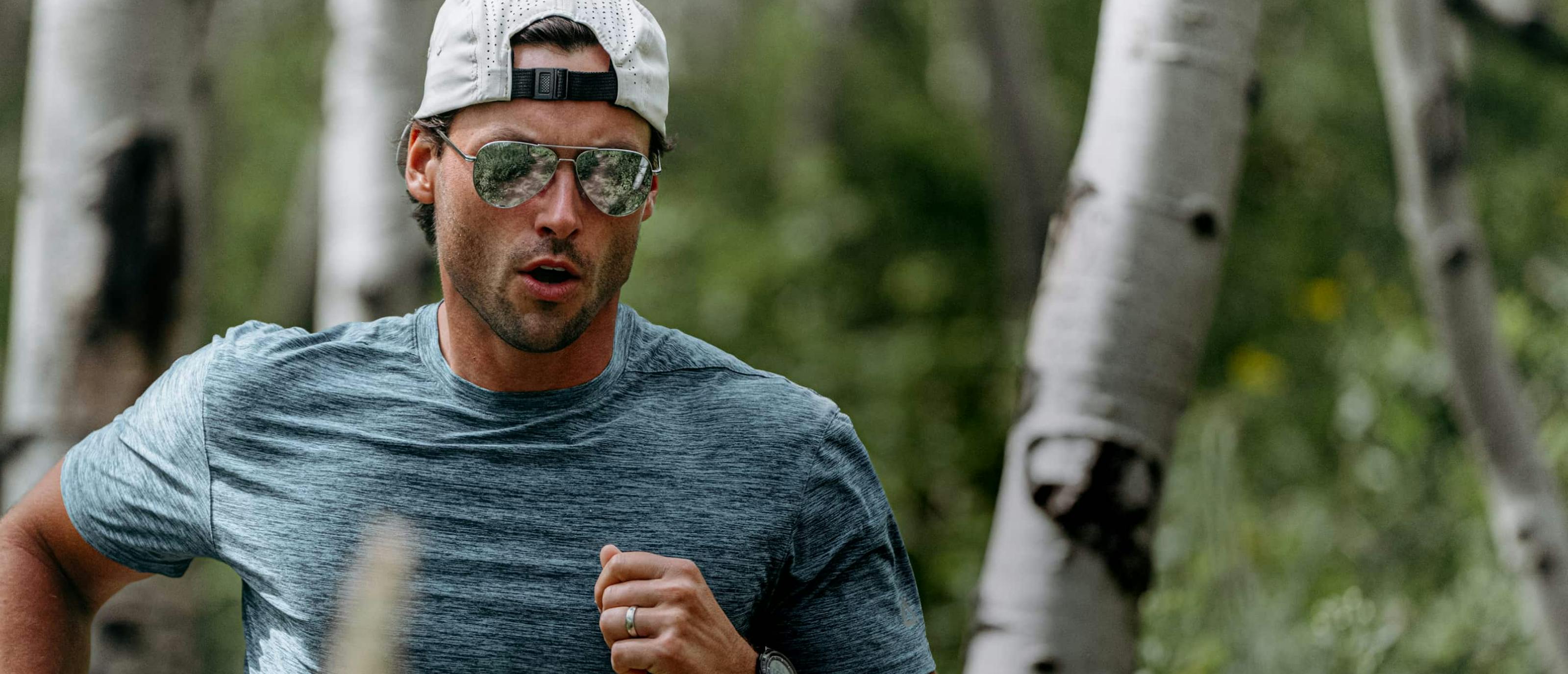 Man running in woods wearing Phantom sunglasses