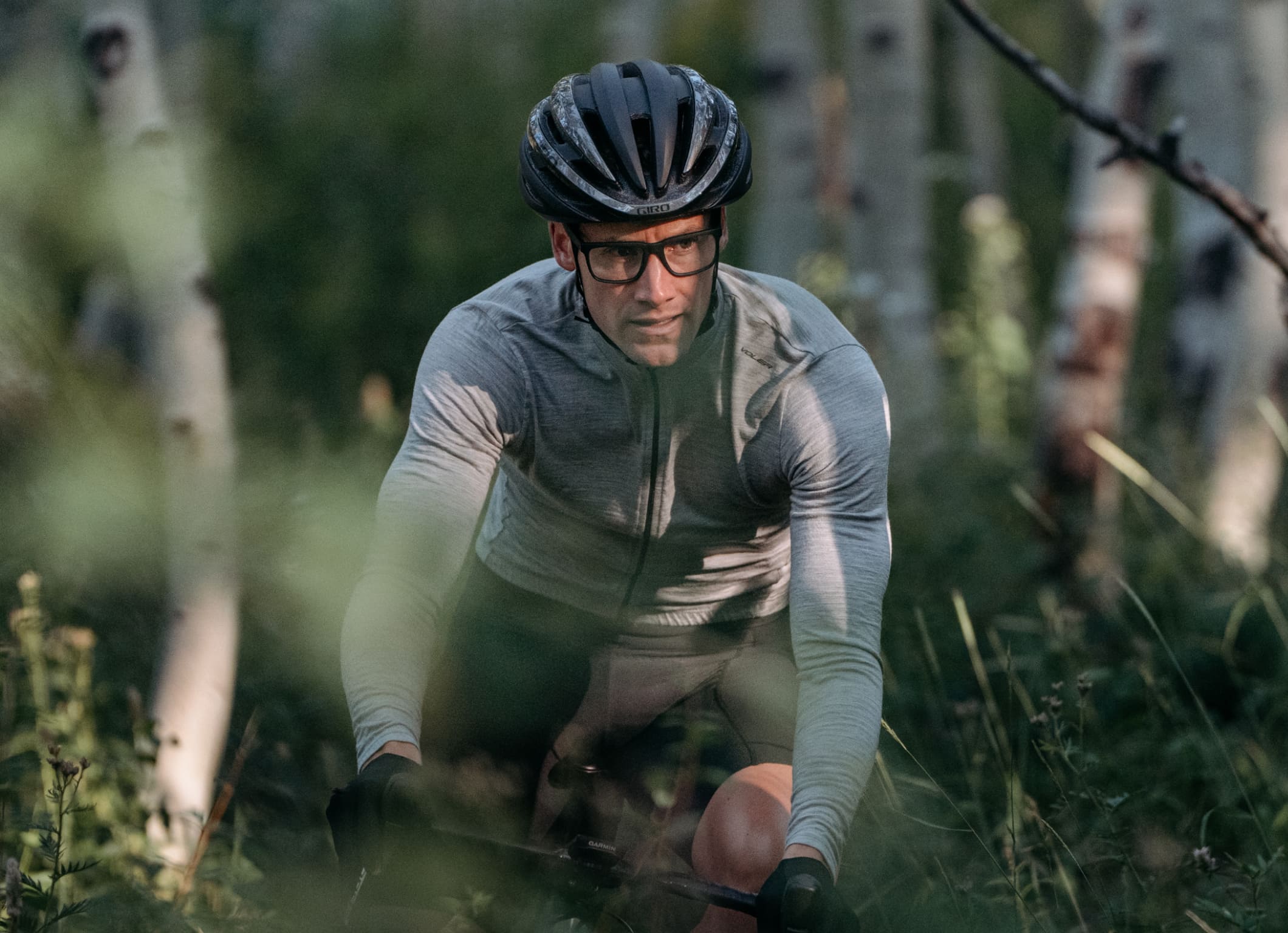 Man biking through trees wearing Barton eyeglasses