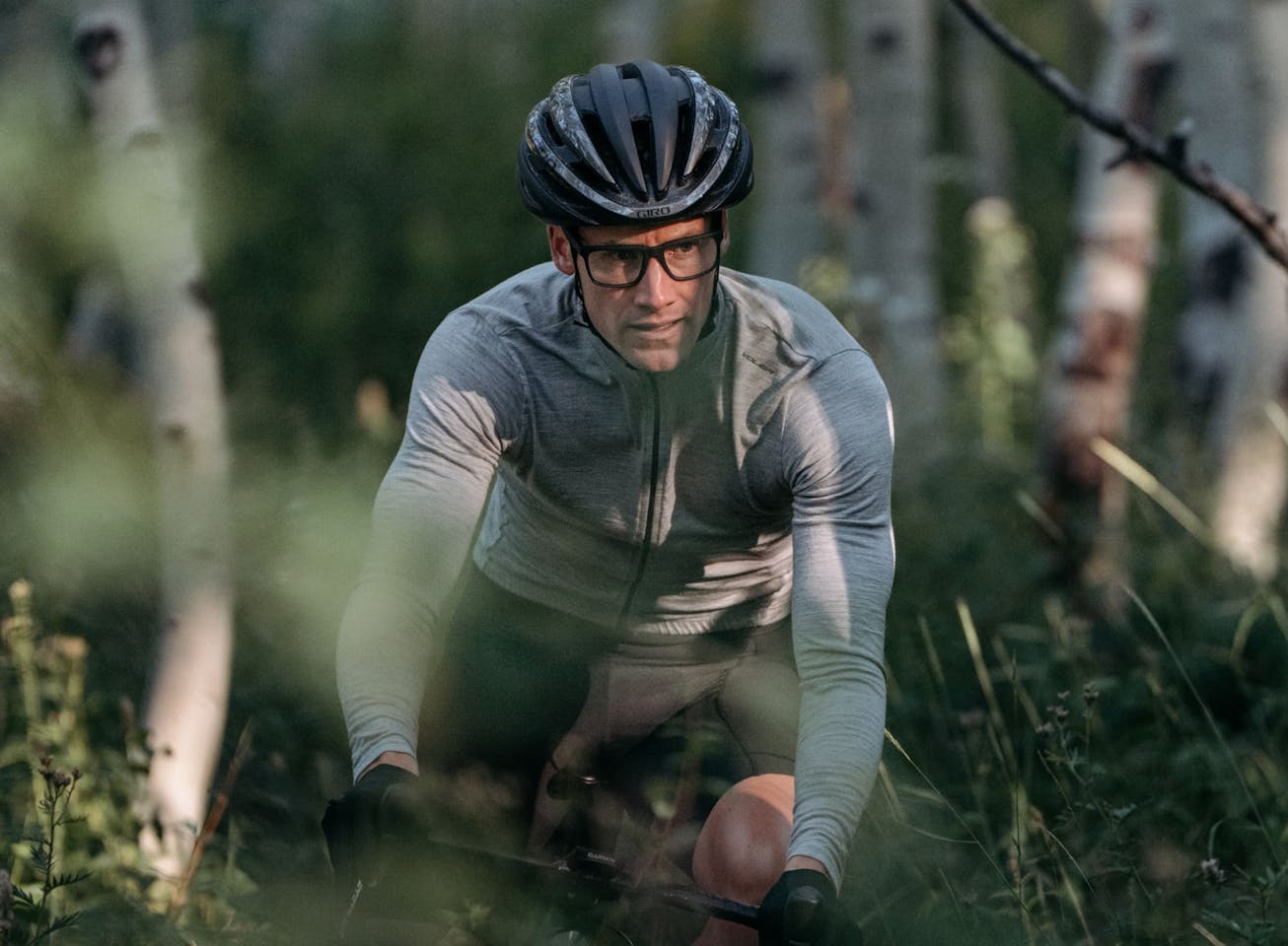 Man biking through trees wearing Barton eyeglasses