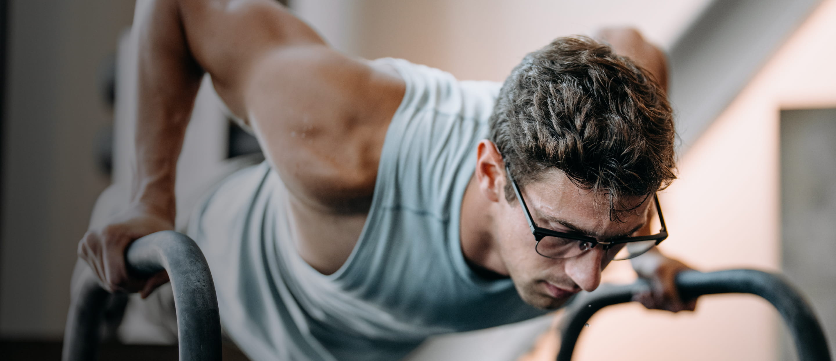 Man exercising in gym looking down wearing Cambridge eyeglasses