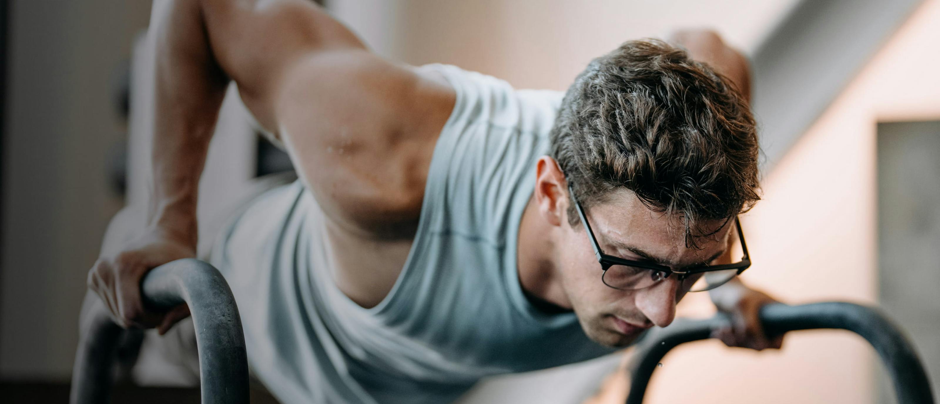 Man exercising in gym looking down wearing Cambridge eyeglasses