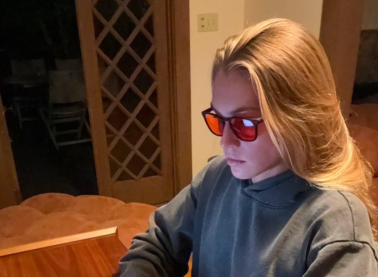 Woman at desk on laptop wearing Red Lens glasses