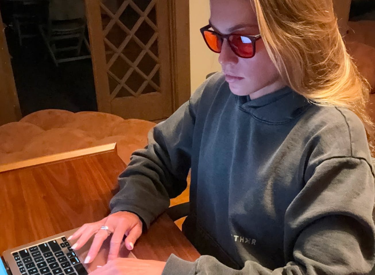 Woman at desk on laptop wearing Red Lens glasses