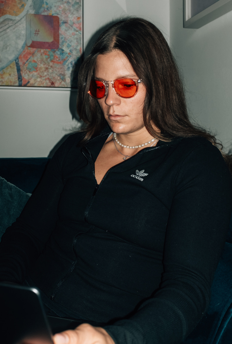 Woman wearing black jacket and Red Lens glasses