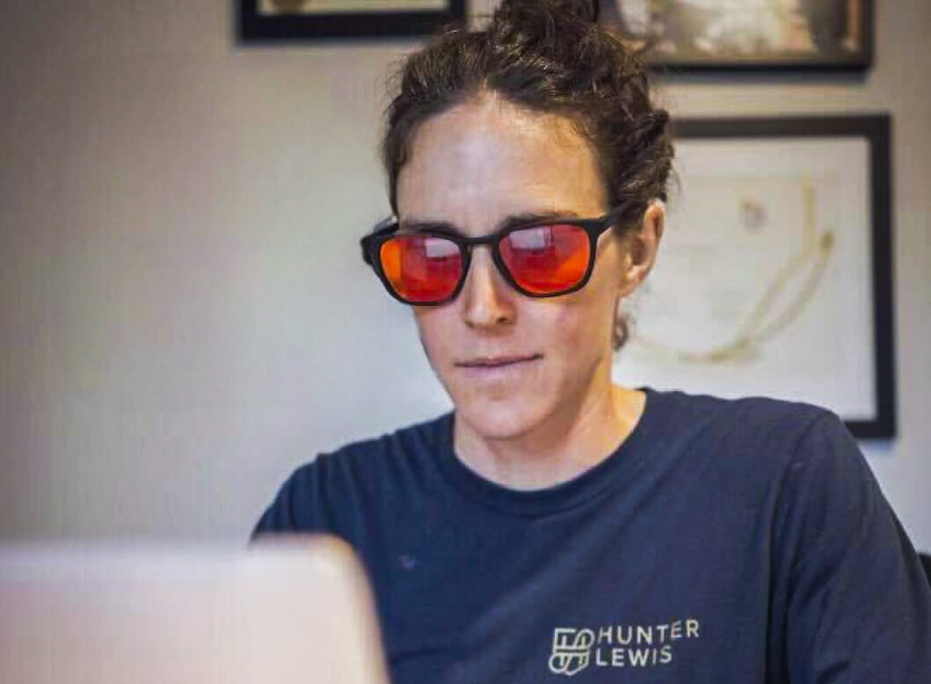 Woman on laptop wearing Red Lens glasses