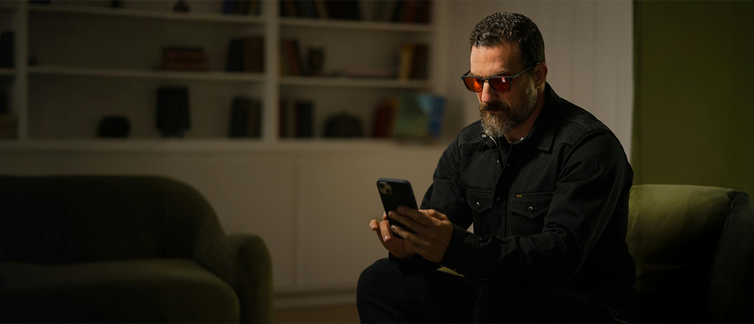 Man sitting in chair looking at his phone