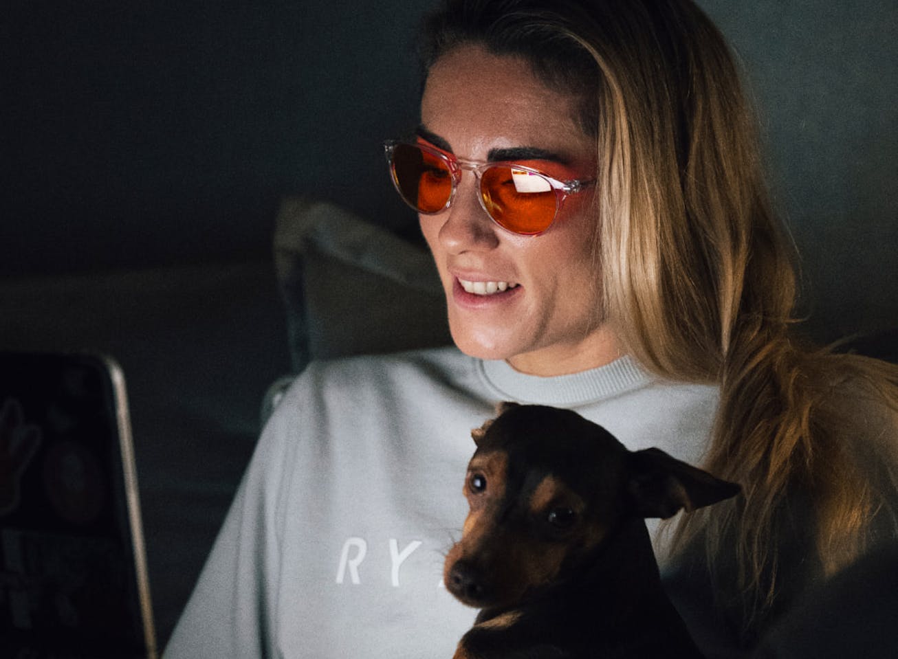 Woman with dog on laptop wearing Red Lens glasses
