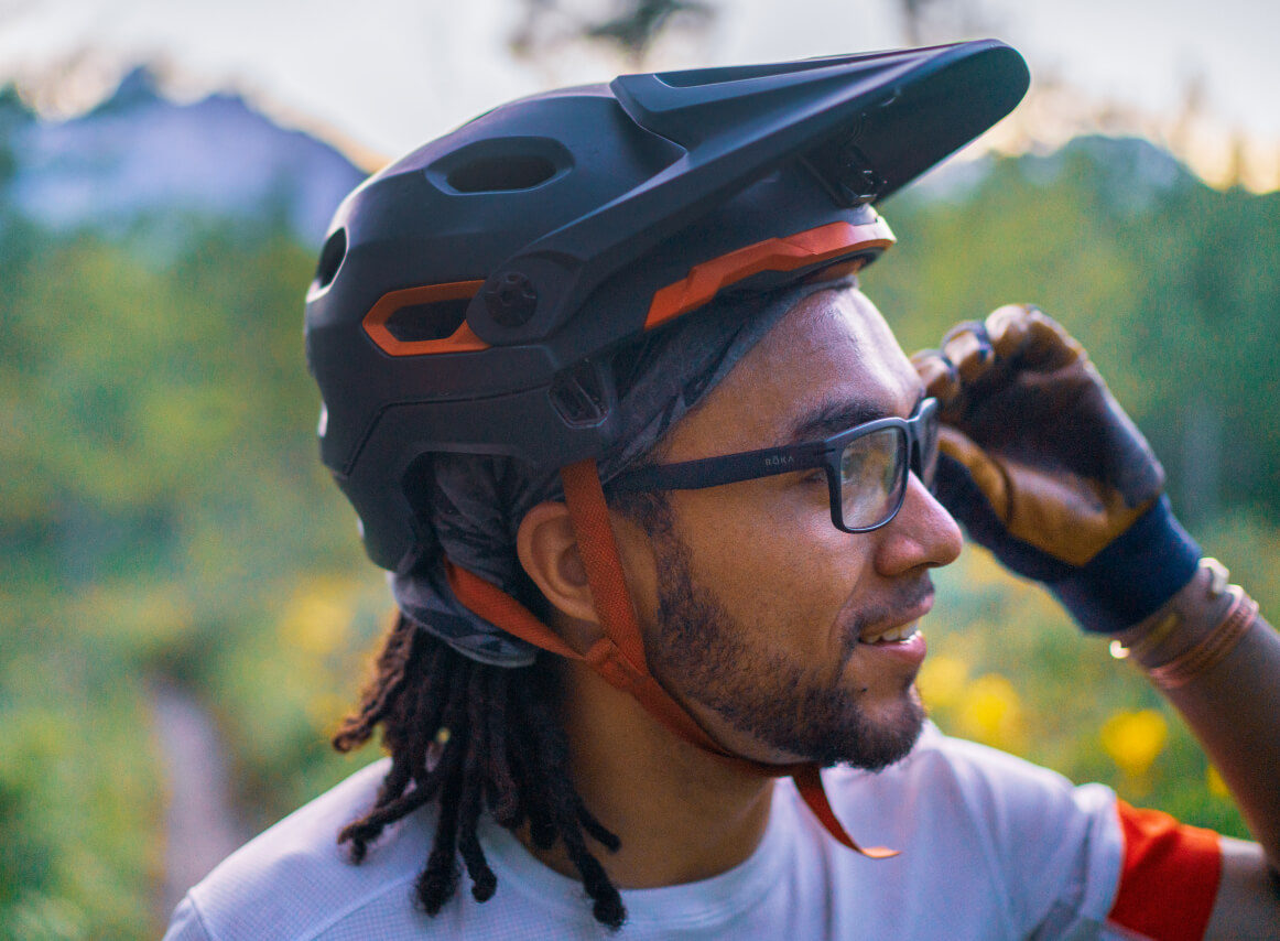 Man adjusting his glasses, wearing Braker eyeglasses 