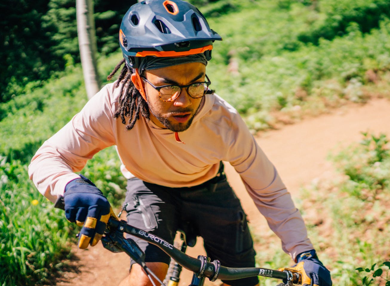 Man riding bike wearing square, matte black/campfire tortoise Hunter eyeglasses