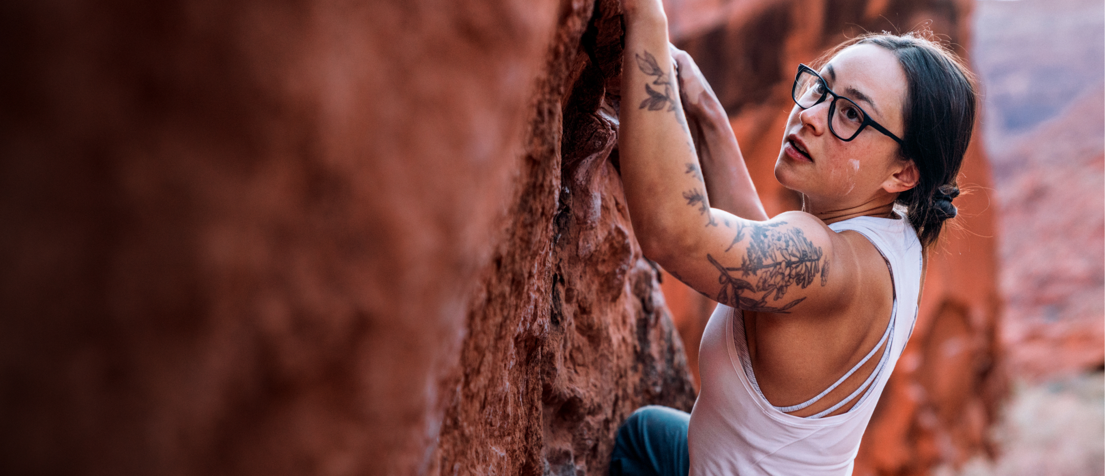 Woman rock climbing wearing rectangular, matte black Rory eyeglasses