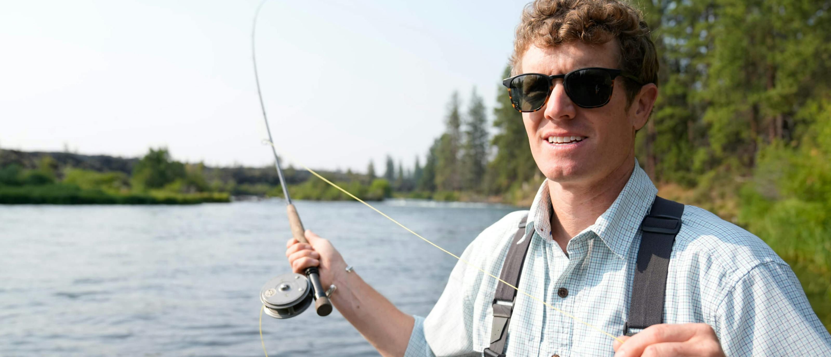 Man casting fishing rod in river