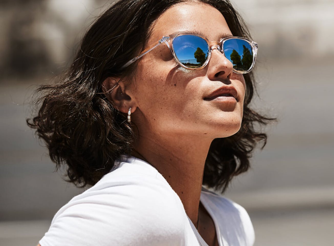 Woman in white top wearing Lola sunglasses