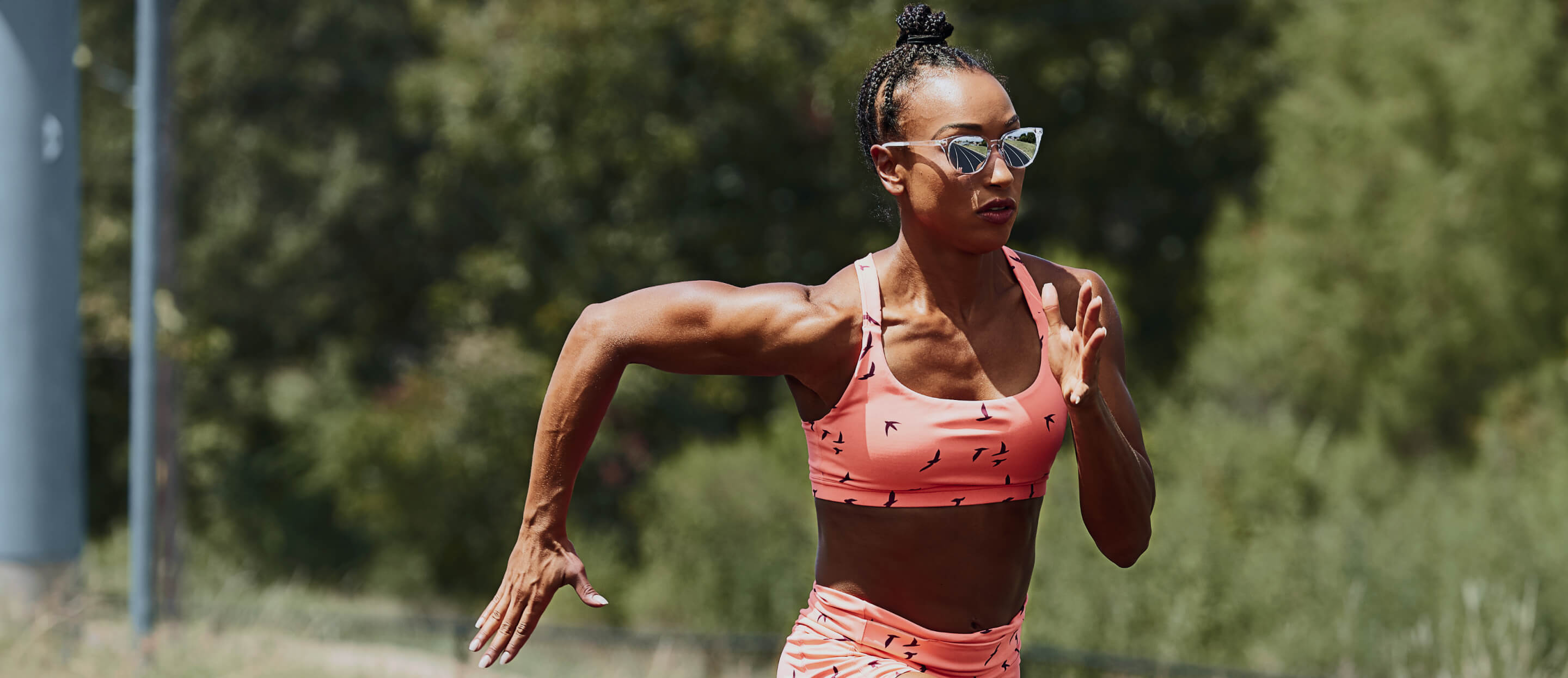 Woman sprinting in pink top and Lola sunglasses