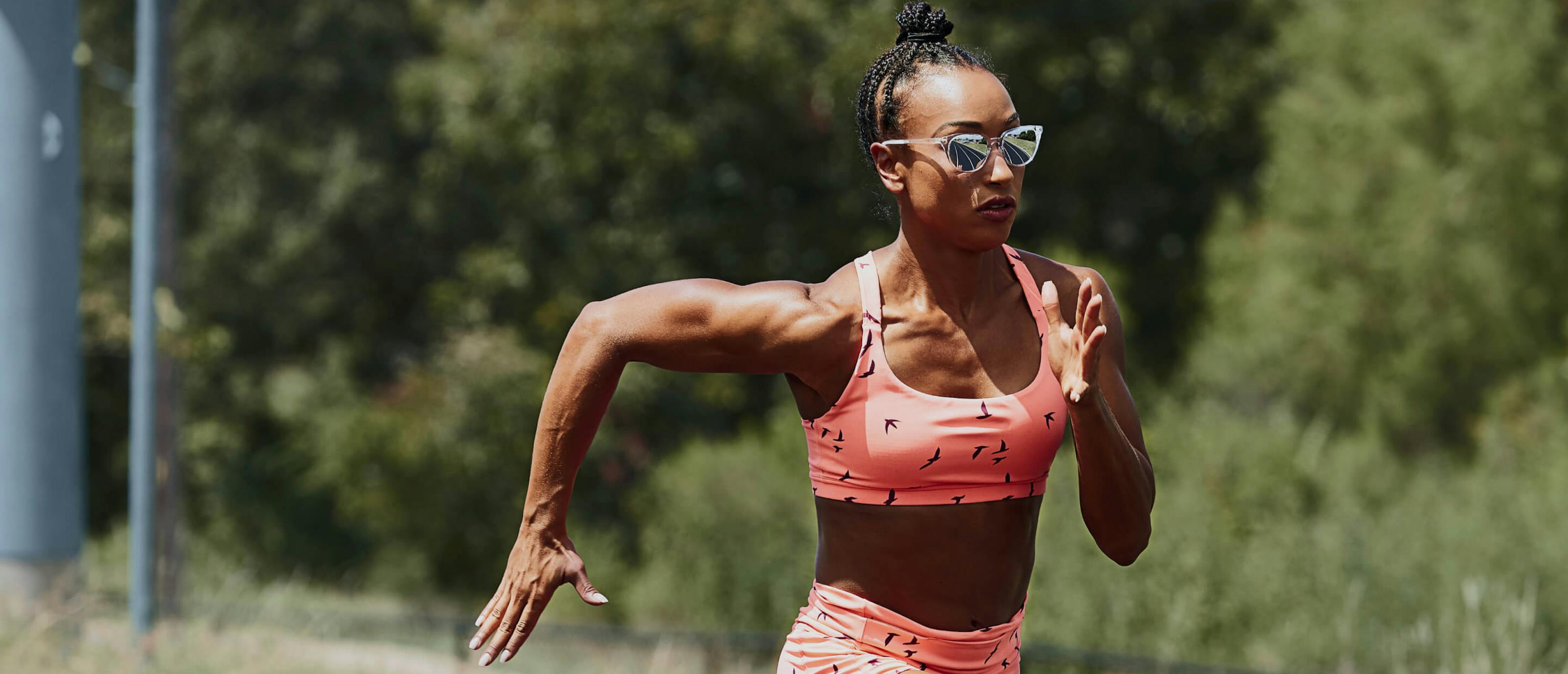 Woman sprinting in pink top and Lola sunglasses