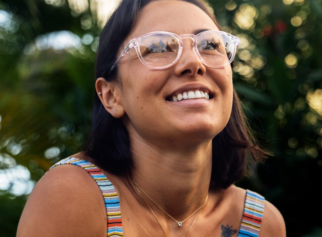 Woman smiling in rainbow rank top and Oslo eyeglasses