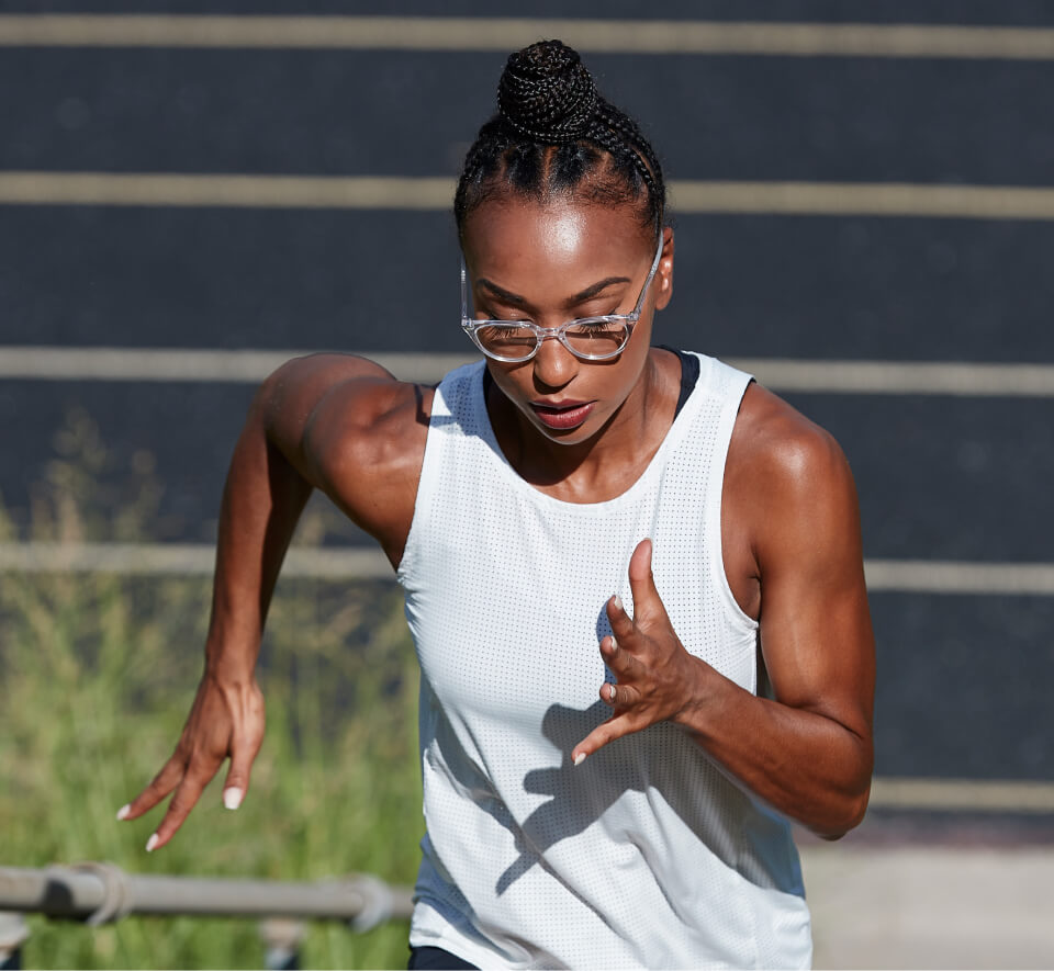 Woman running near track in Lola eyeglases