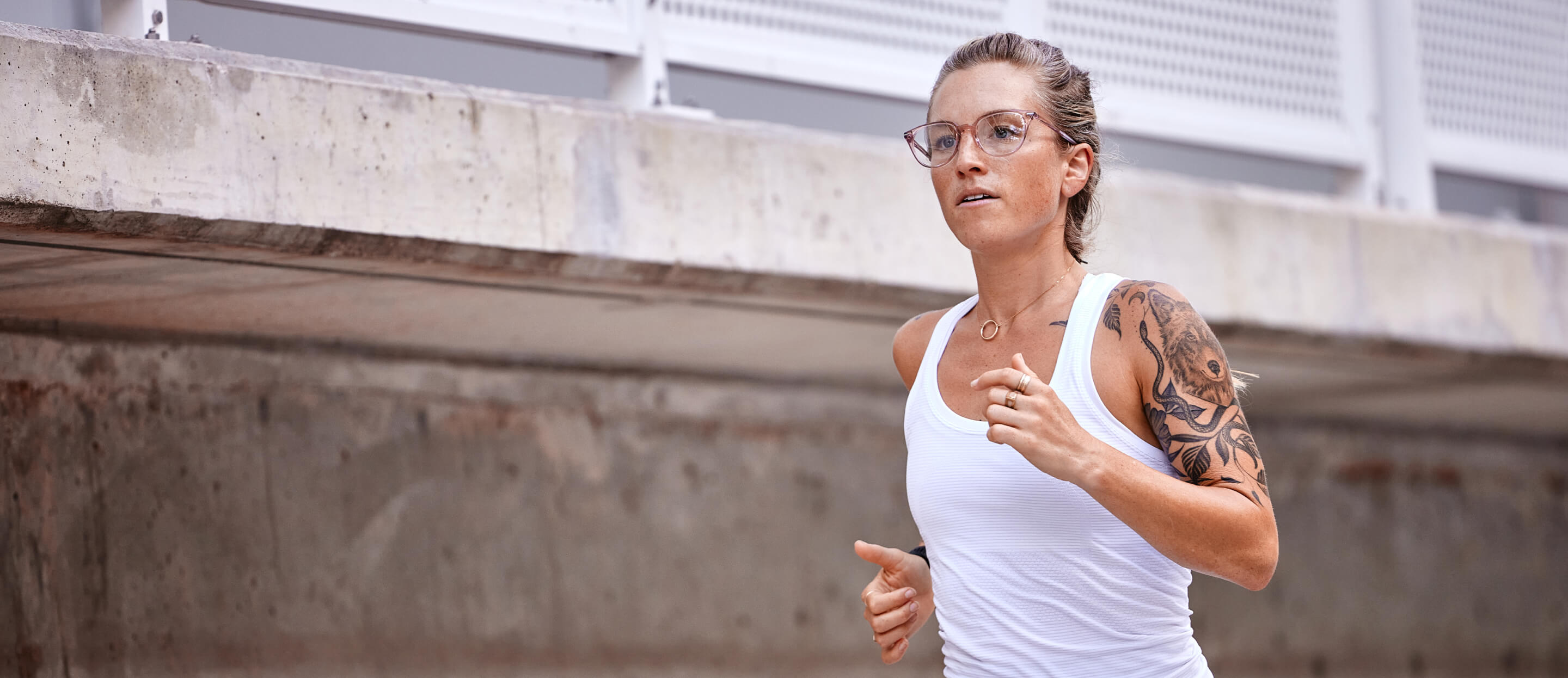 Woman running in white top in Lola eyeglasses
