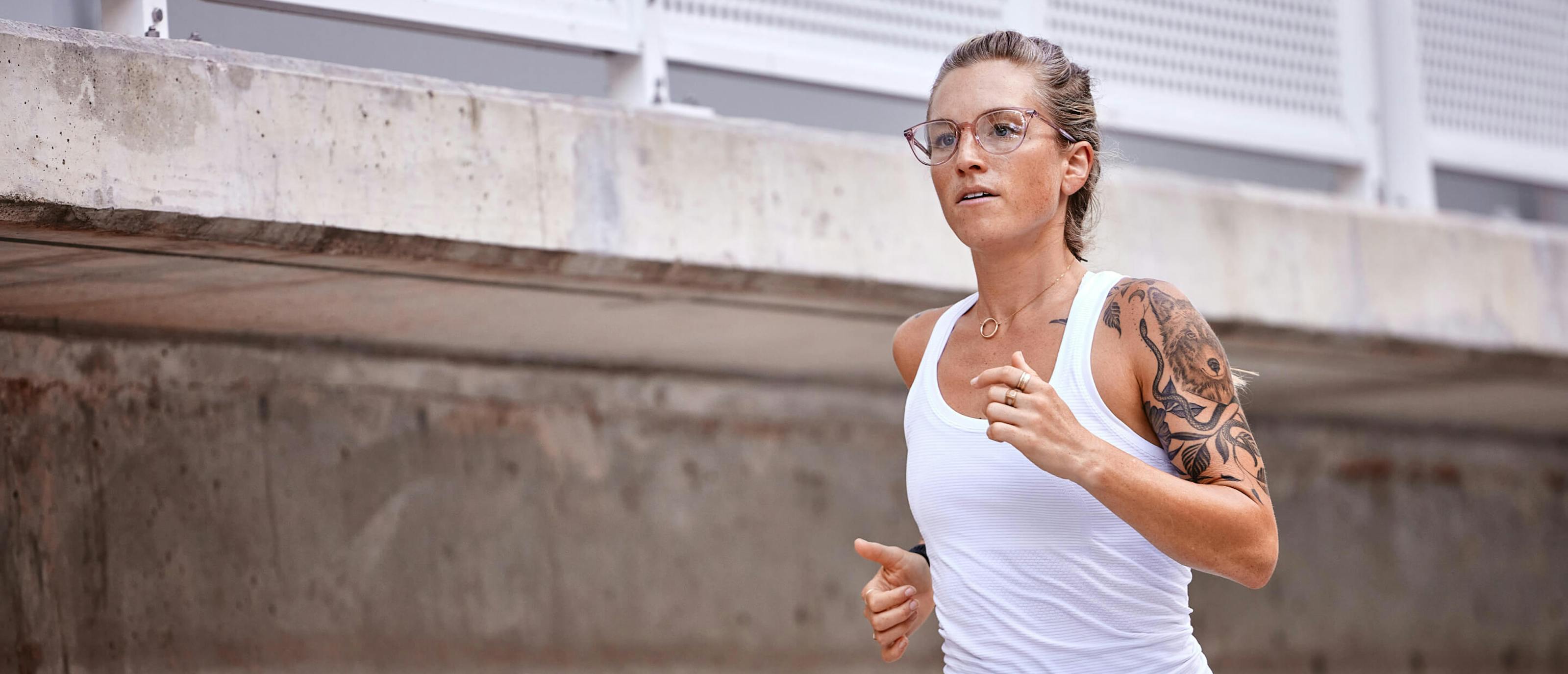 Woman running in white top in Lola eyeglasses