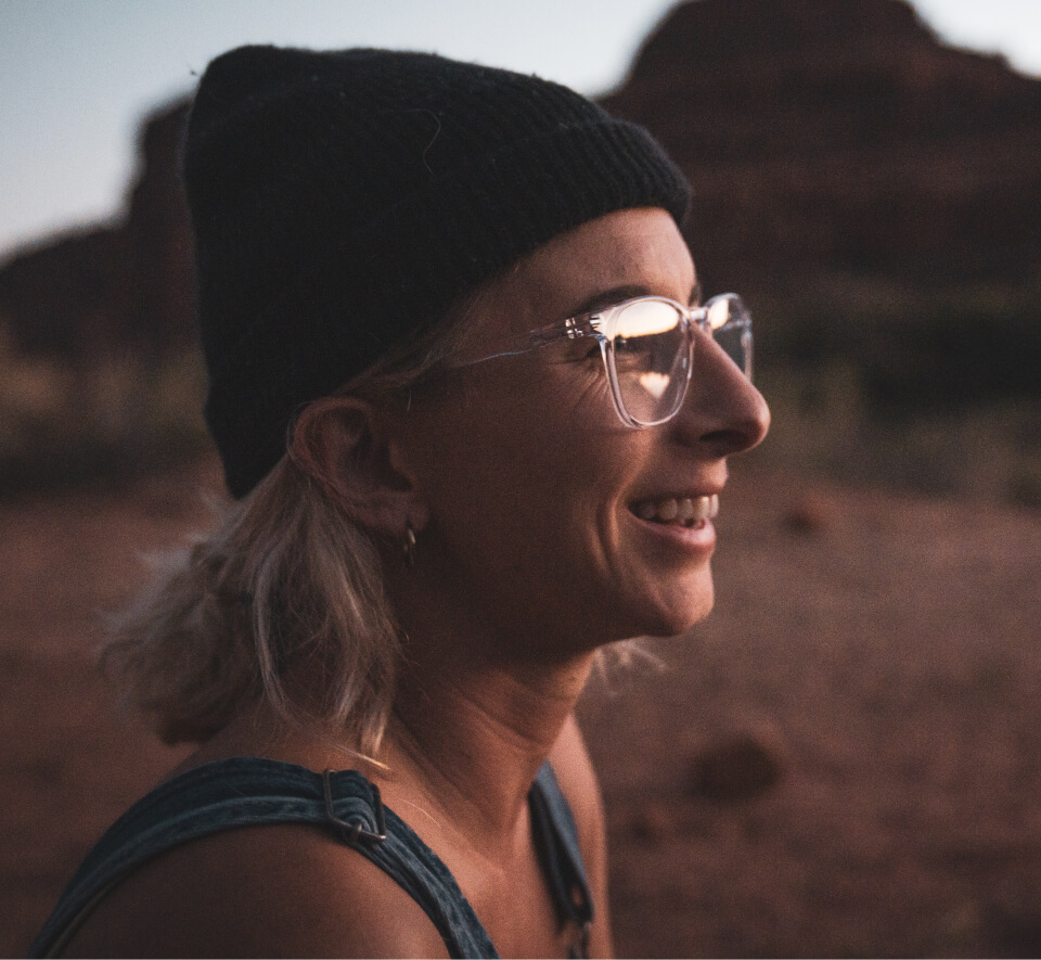 Woman in desert wearing black beanie and Hunter eyeglasses