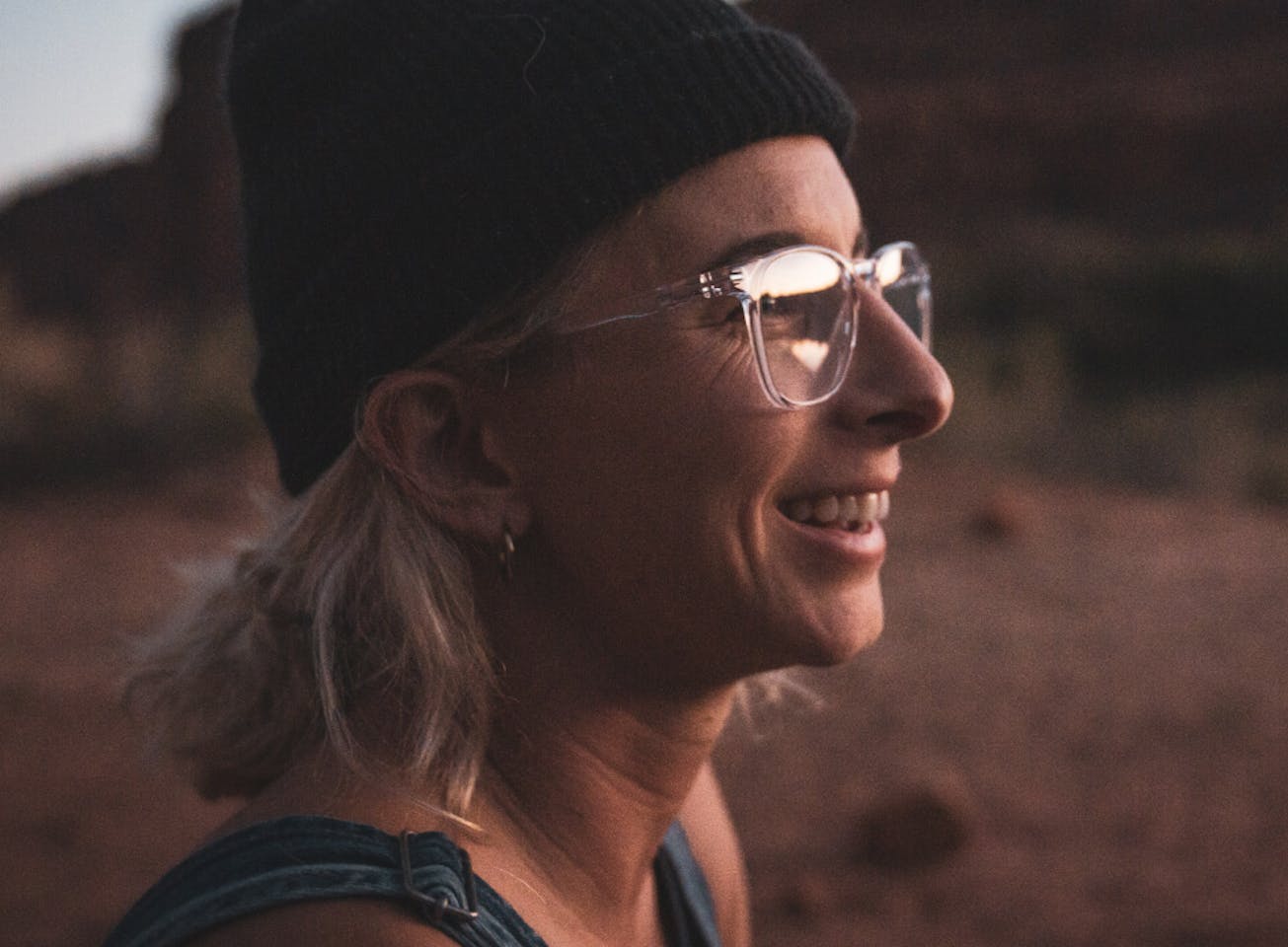 Woman in desert wearing black beanie and Hunter eyeglasses