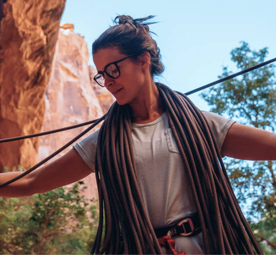 Woman organizing rock climbing rope wearing Hunter eyeglasses