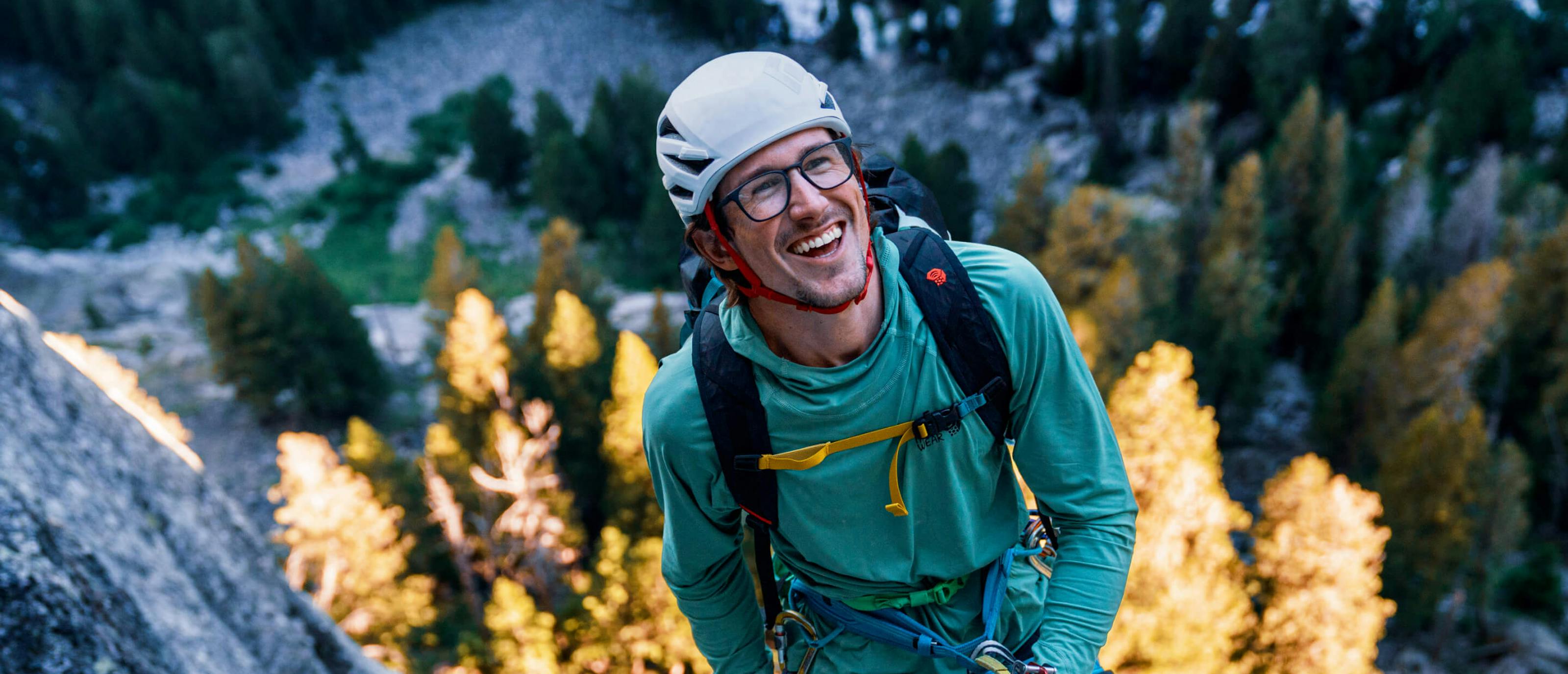 Man in blue jacket rock climbing