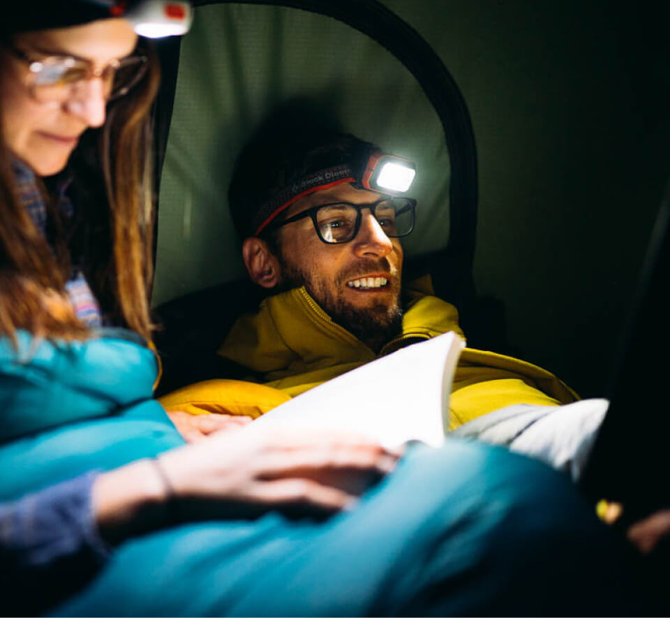 Man using headlamp in camping tent wearing Rory eyeglasses