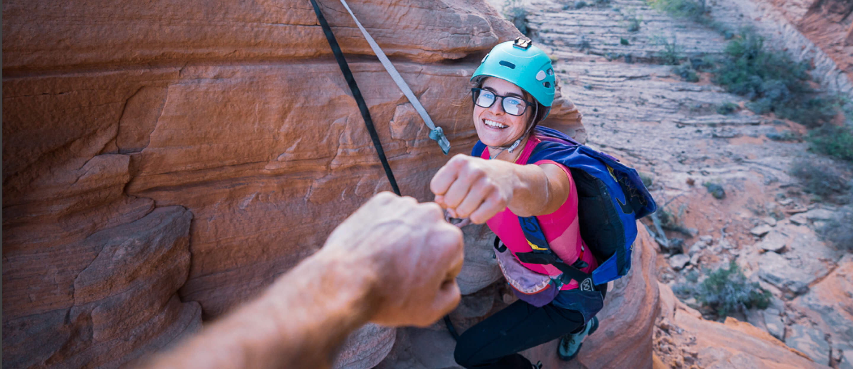 Woman in rock climbing gear giving a fist bump