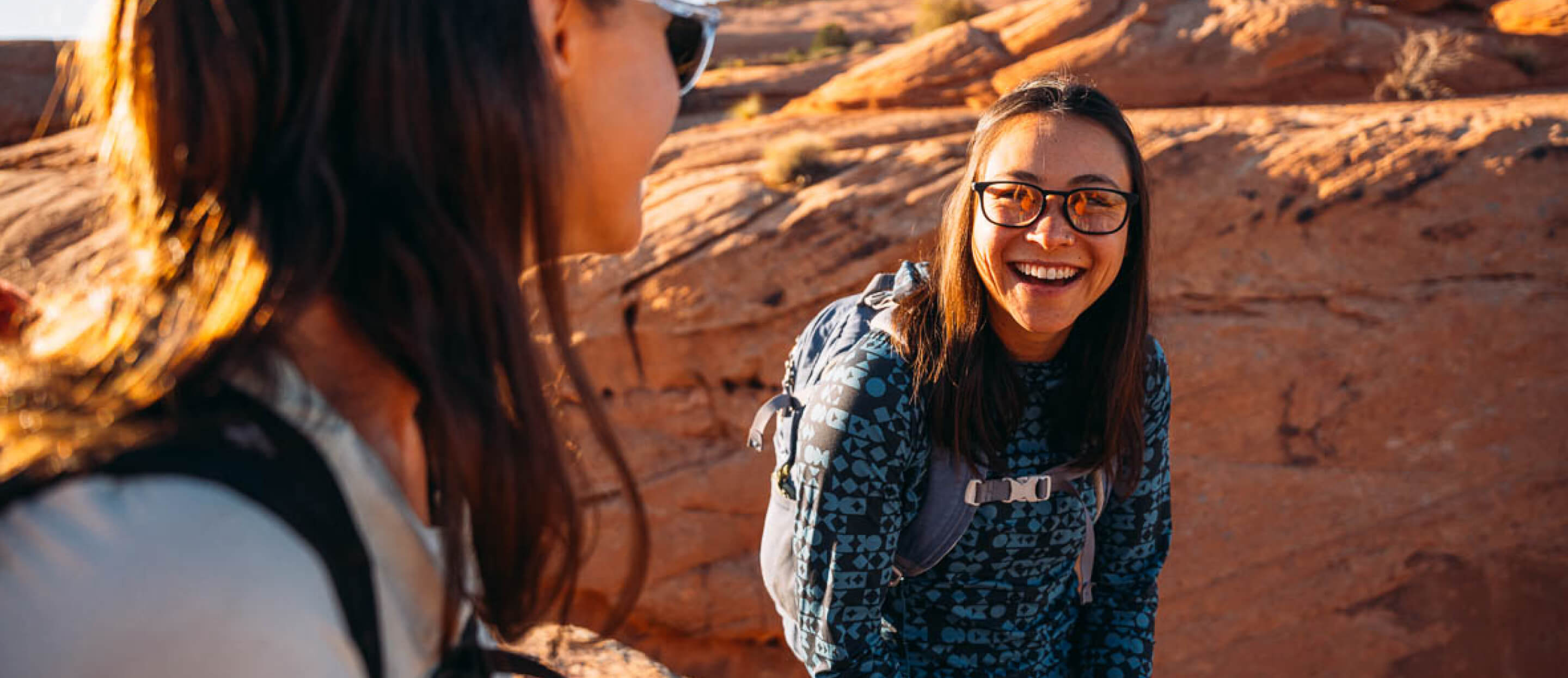 Woman laughing with friend on a hike wearing Cade Eyeglasses