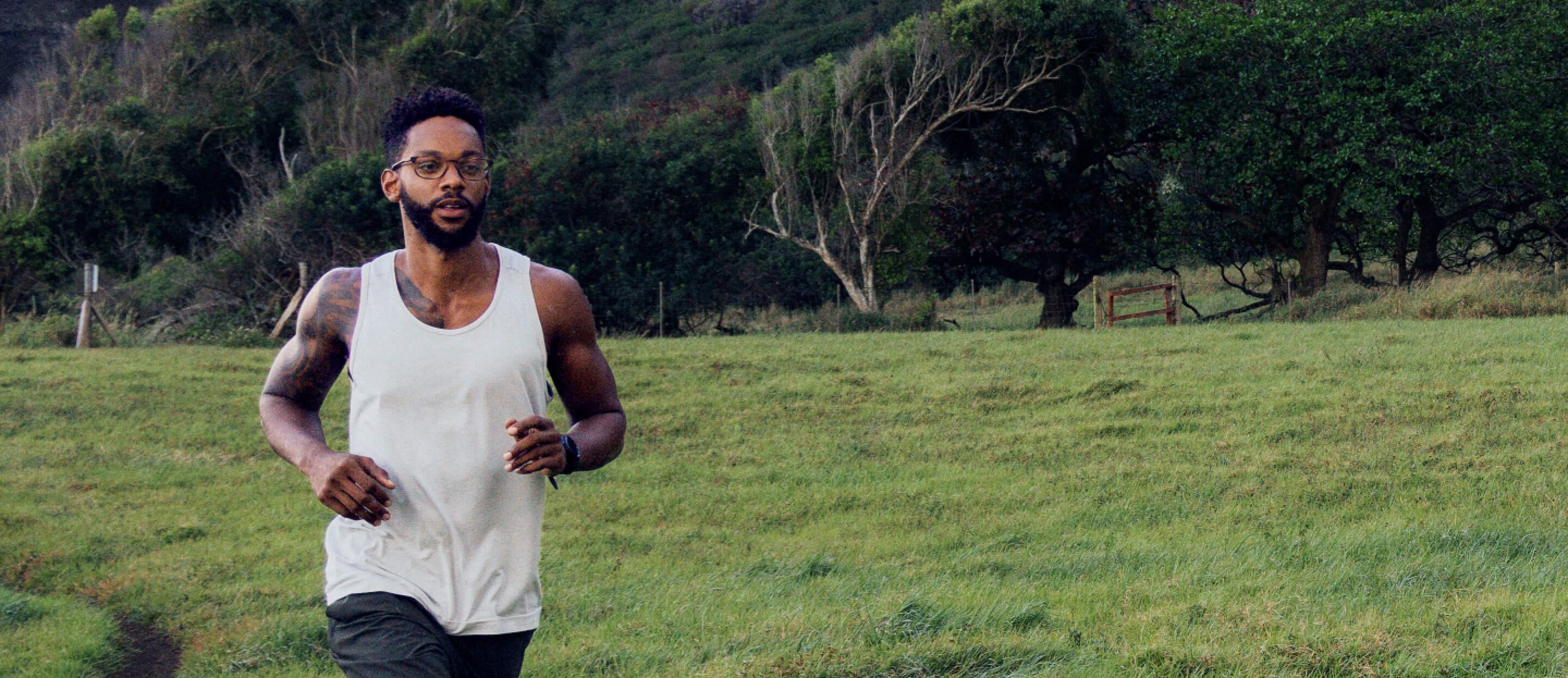 Man jogging near grassy hill wearing Cade eyeglasses