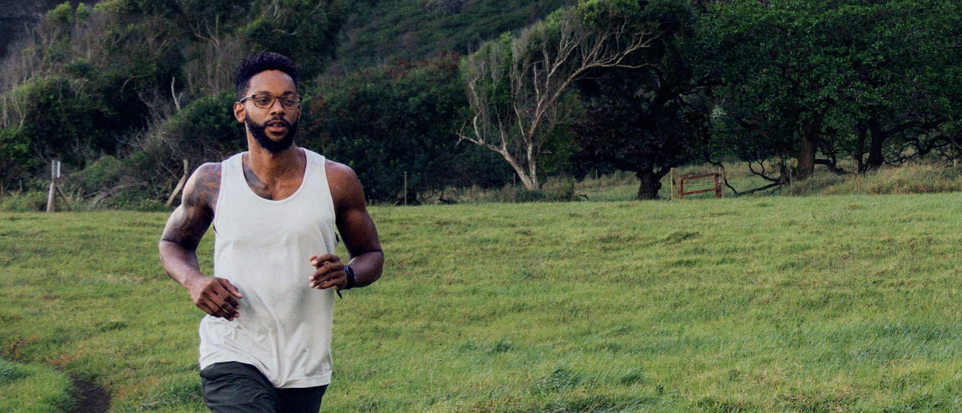 Man jogging near grassy hill wearing Cade eyeglasses