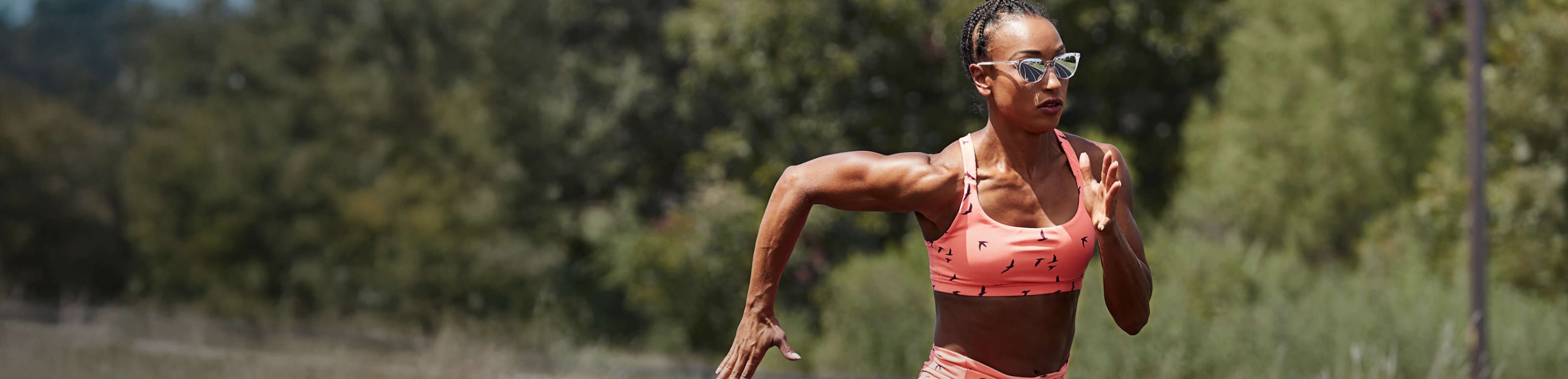 Woman running in pink top and Lola sunglasses