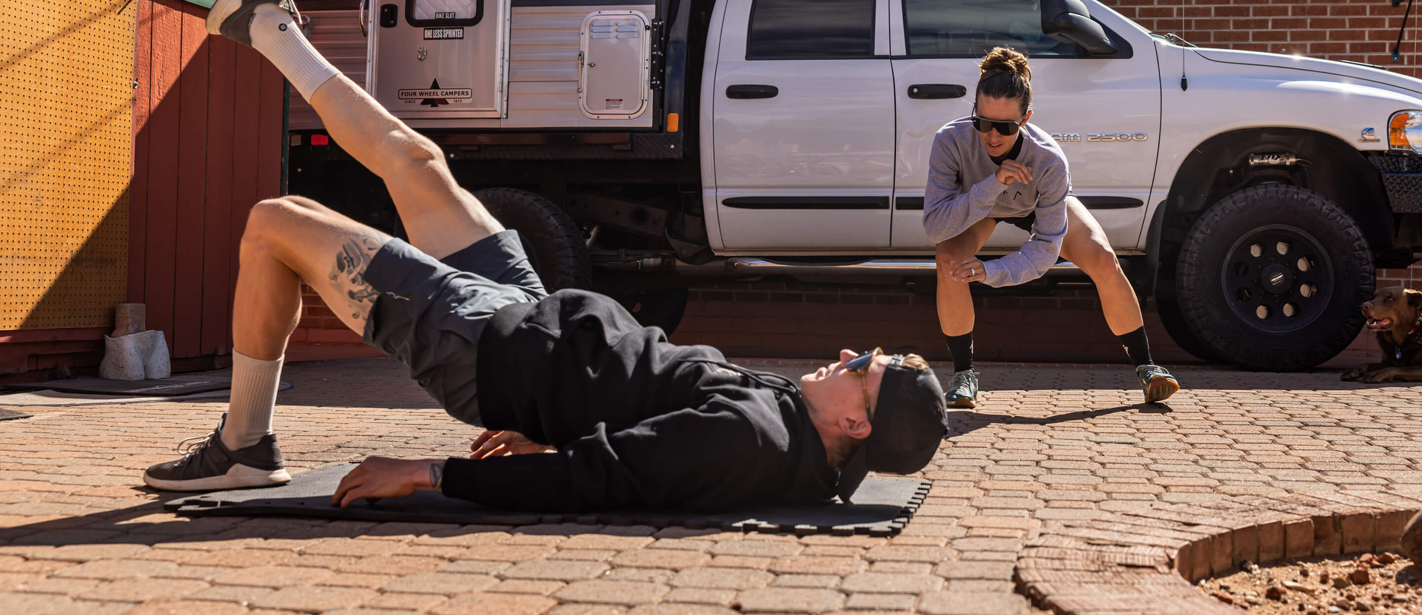 Man and woman working out next to truck in ROKA sweatshirts
