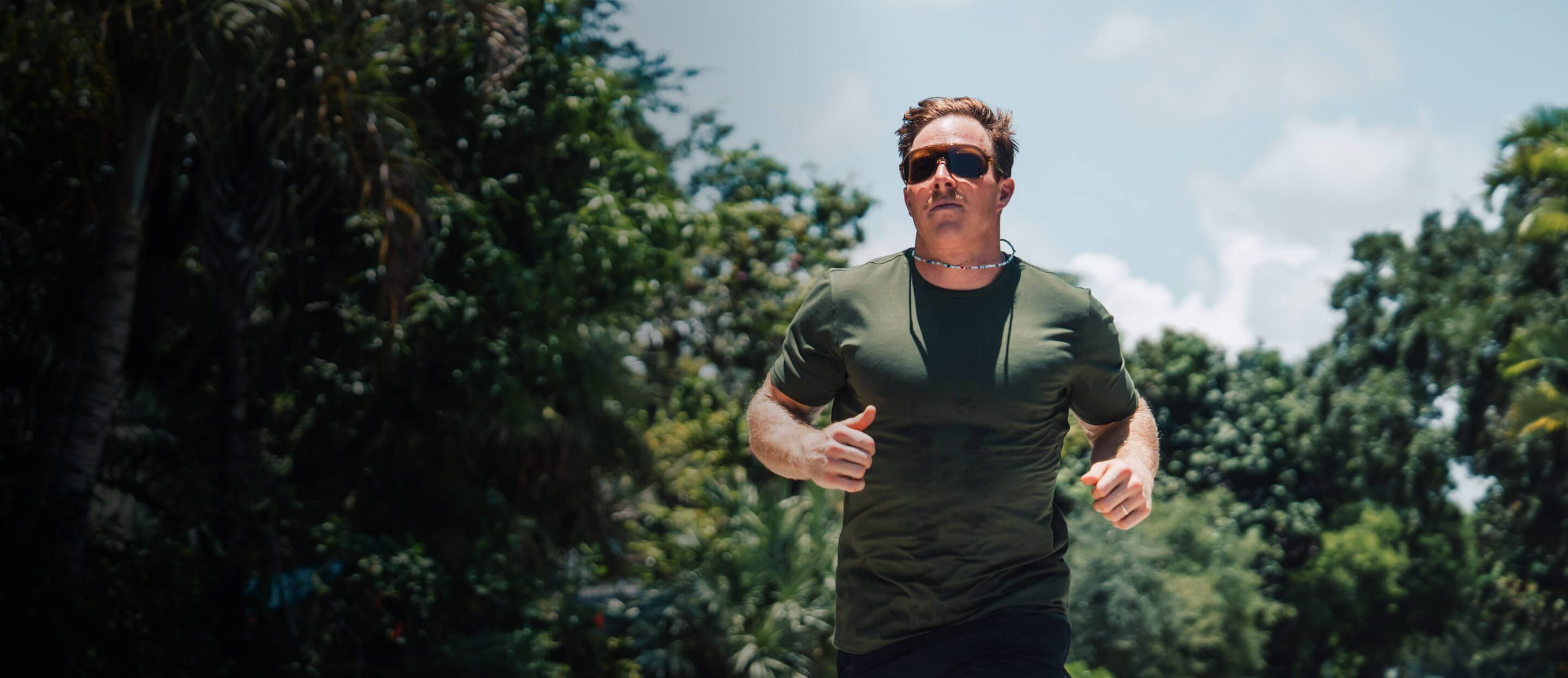 Man jogging in front of trees