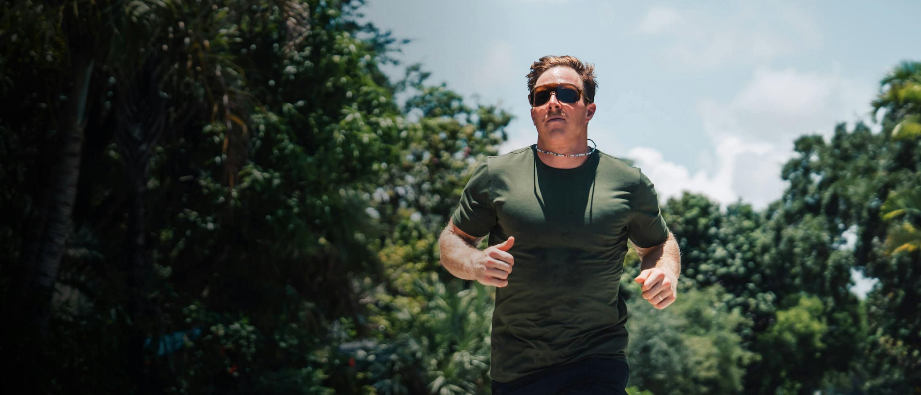 Man jogging in front of trees