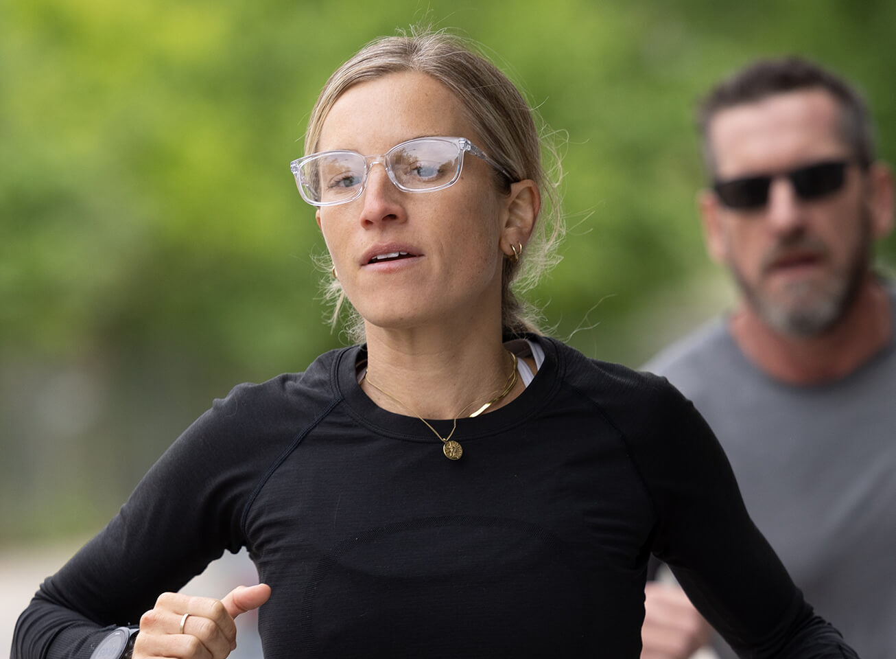 Woman jogging in black top and Palmer eyeglasses