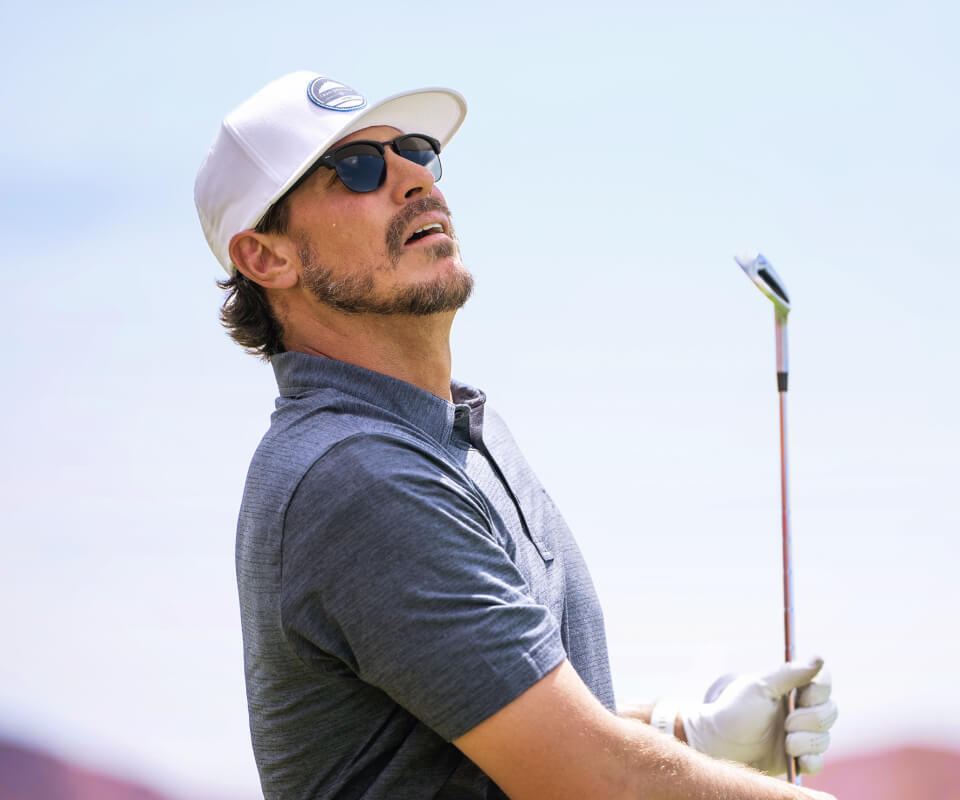 Man in white hat holding golf club