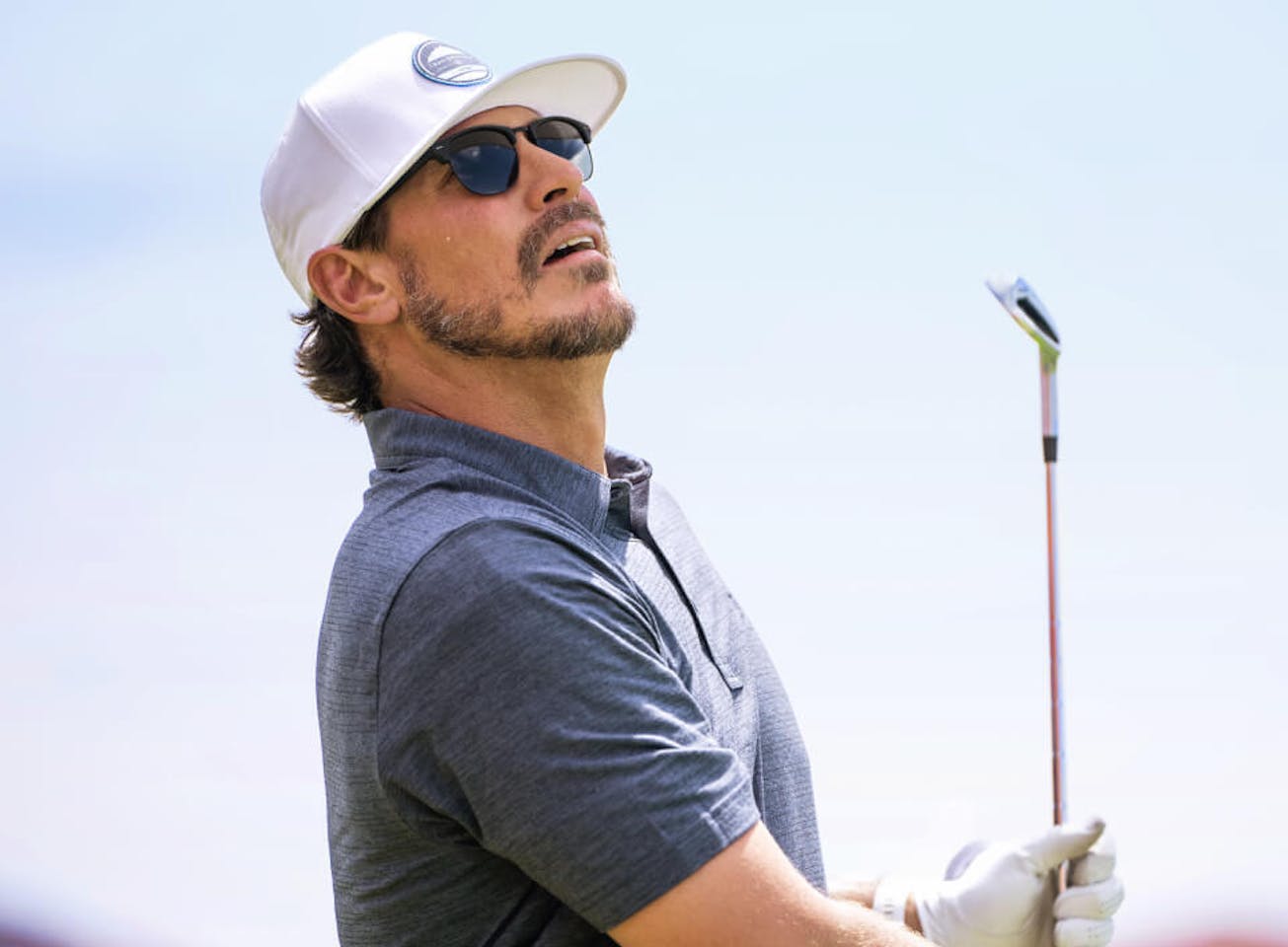 Man in white hat holding golf club