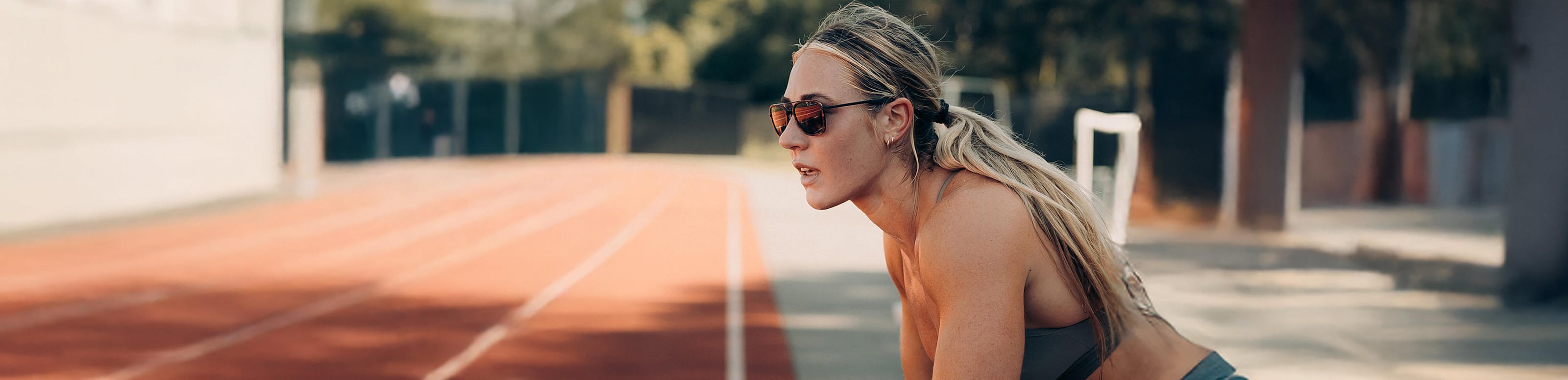 Woman on running track in Falcon sunglasses