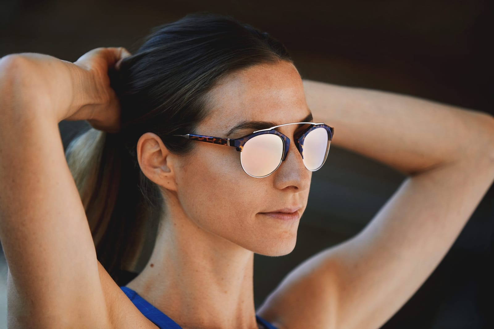 Woman tying back hair in Mallorca sunglasses