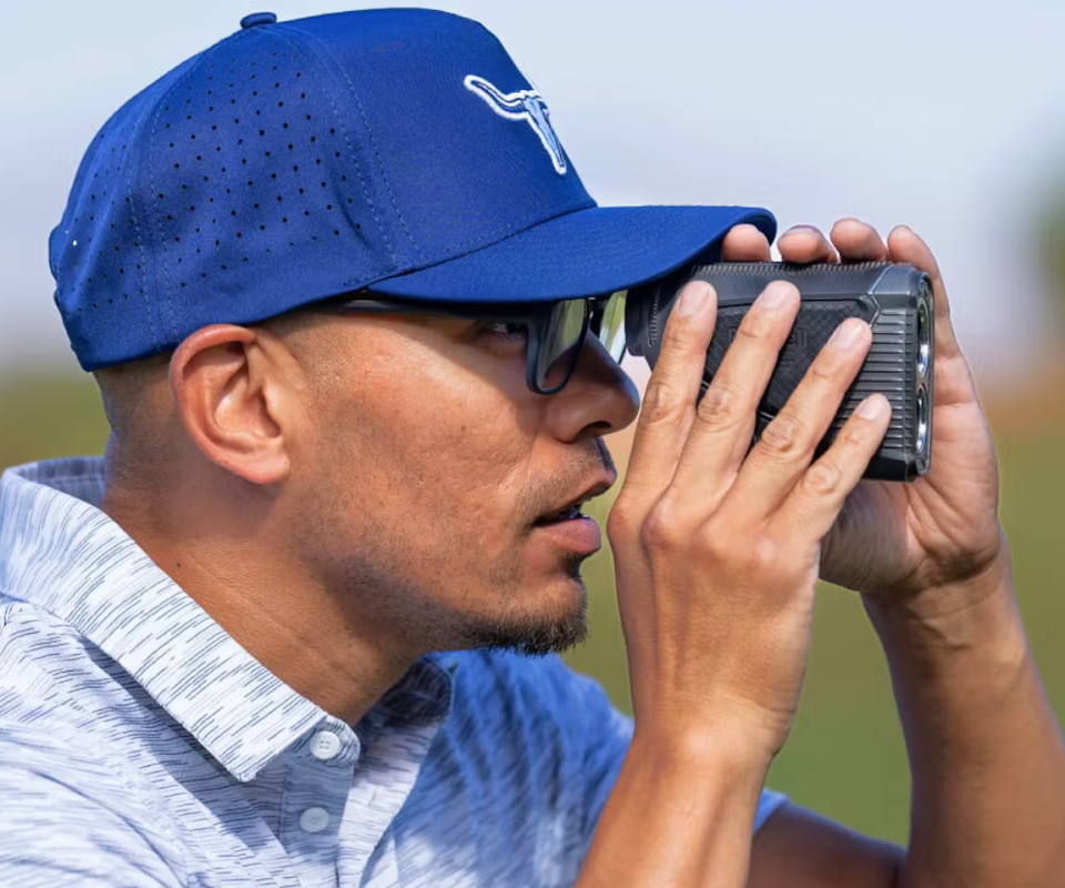 Man using range finder wearing blue hat