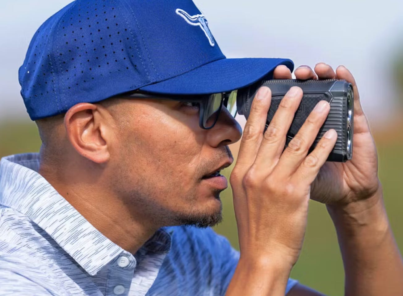 Man using range finder wearing blue hat