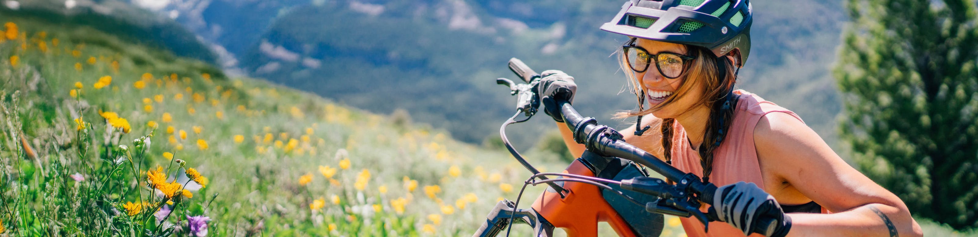 Woman pushing mountain bike wearing Lola eyeglasses