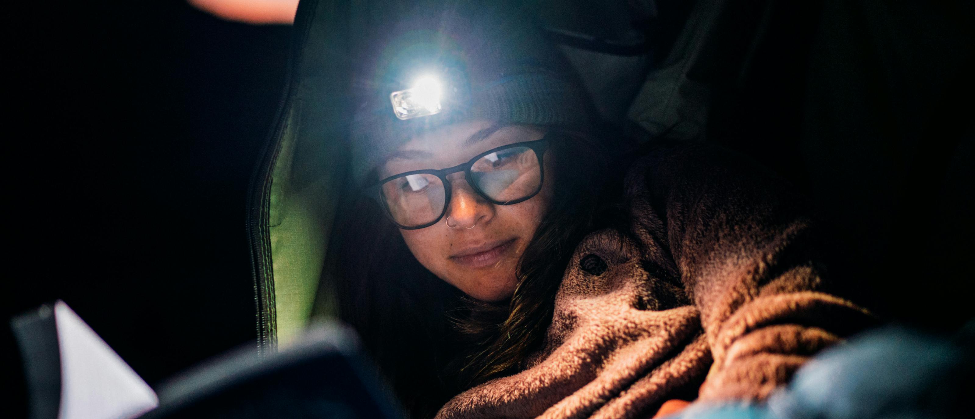 Woman reading with headlamp and Hunter eyeglasses