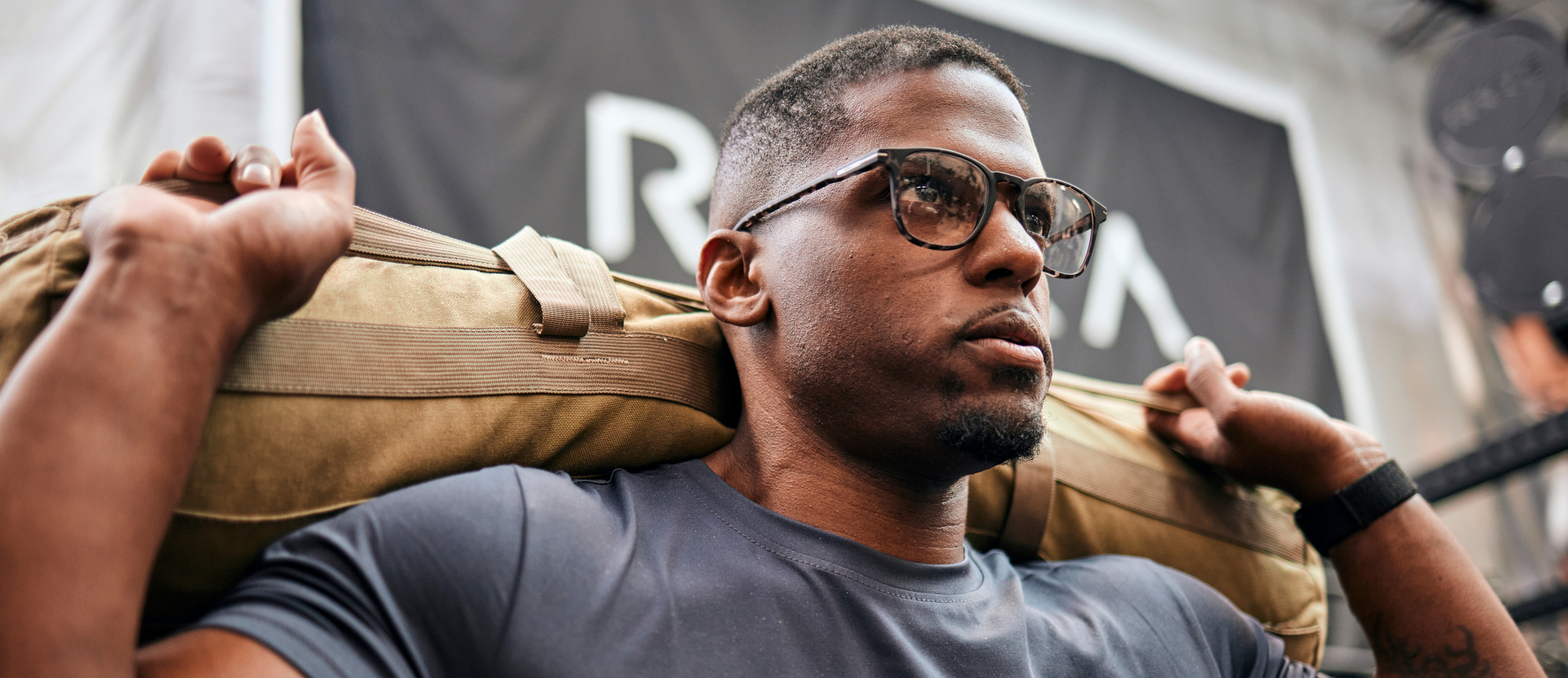 Man carrying sandbag wearing Hunter eyeglasses