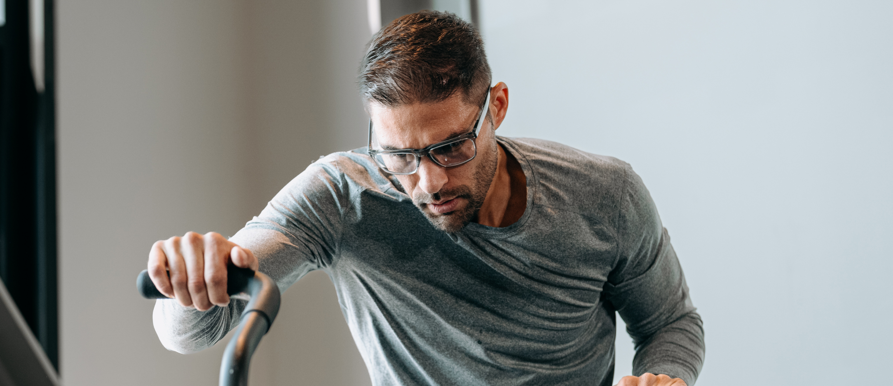 Man on stationary bike and Barton eyeglasses
